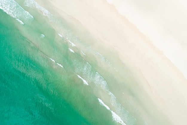 Вид сверху на красивый белый песчаный пляж с бирюзовой морской водой