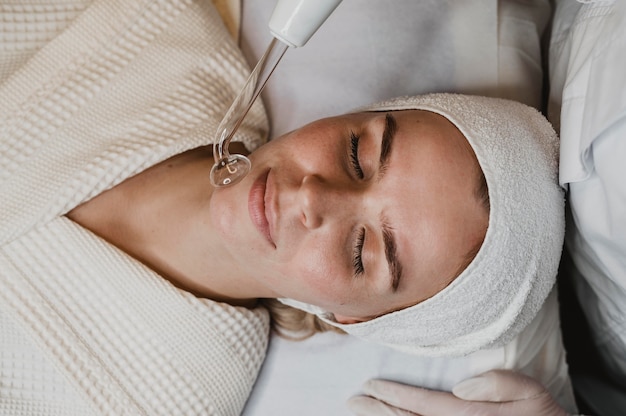 Photo top view of beautiful woman getting a facial treatment