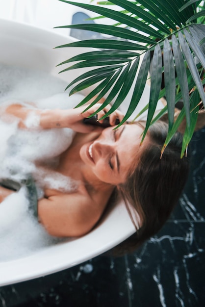 Foto vista dall'alto la bella giovane donna ha tempo libero a casa nella vasca da bagno