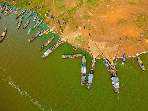 Top View of Ben Nom fishing village fresh green image of the green algae season on Tri An lake with many traditional fishing boats anchored in Dong Nai Vietnam