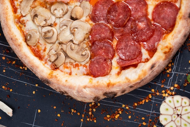 Foto top view su una grande pizza assortita di quattro stagioni con una varietà di topping