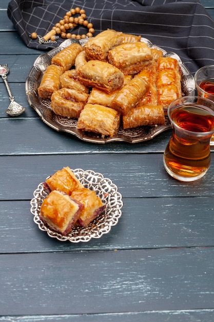 Top view of big metal tray with turkish baklava on planked wooden table