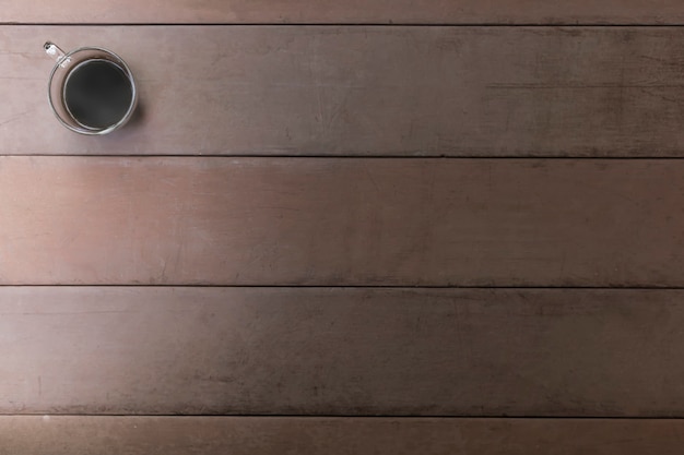 Photo top view black coffee cup on old wood table. coffee in handle cup with copy space. hot black coffee with smoke.