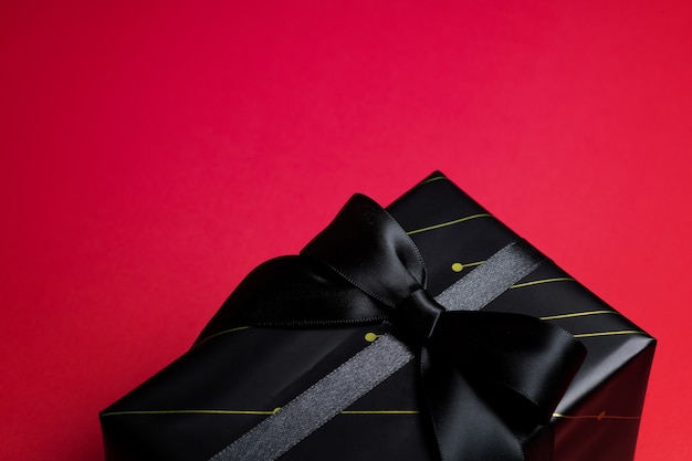 Top view of black gift box with black ribbons isolated on black