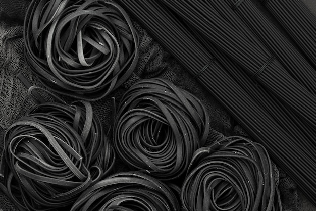 top view of black tagliatelle and spaghetti