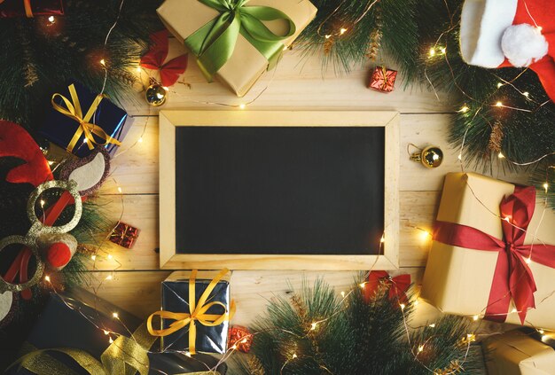 Top View of Blackboard Surrounded By Christmas Gifts Ornament. Copy Space