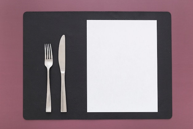 Photo top view of blank menu paper with knife and fork