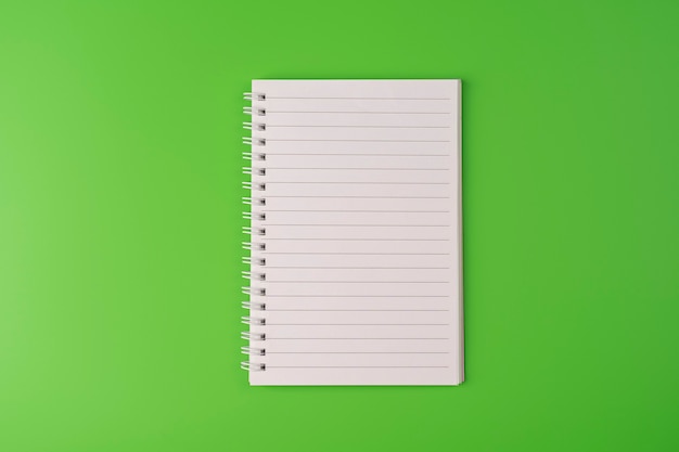 Top view of blank note paper on green background Back to school and education concept copyspace