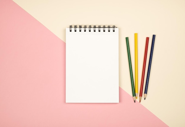 Top view of blank notebook page with colored pencils on table Flat lay