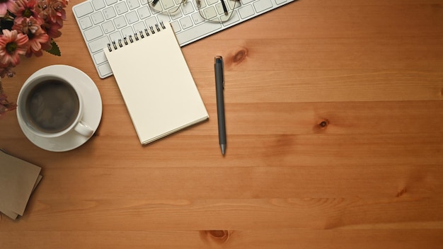 Photo top view of blank notepad cup of coffee wireless headphone and mouse on wooden table copy space for your text