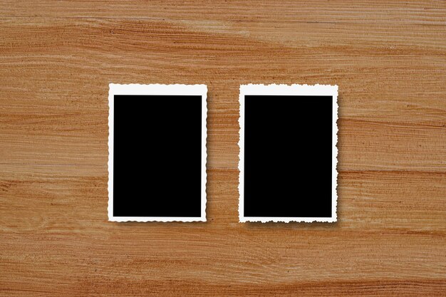 Photo top view of blank photo frames on wooden table background