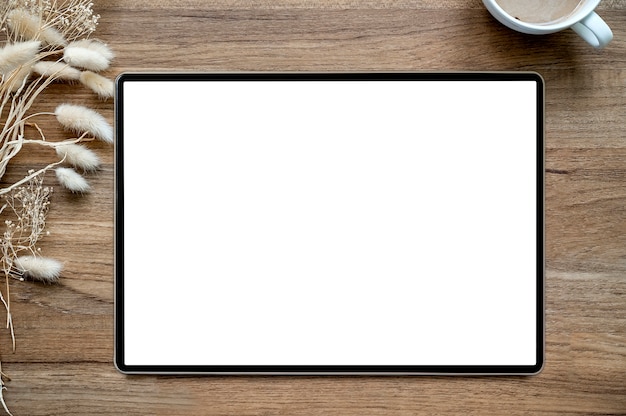 Top view of blank screen tablet on wooden background office desk .