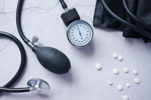 Photo top view of blood pressure machine and medical pill on table