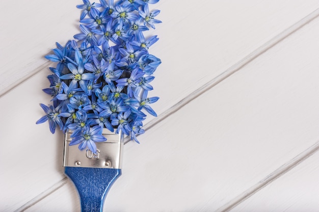 Top view of blue flowers composition and paint brush