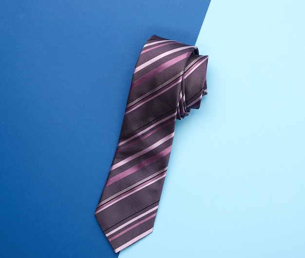 Top view on blue silk tie on blue background