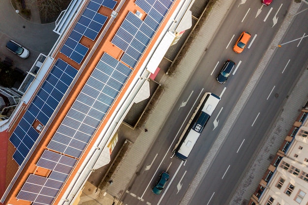 Top view of blue solar photo voltaic panels system on high apartment building roof top on sunny day. Renewable ecological green energy production concept.