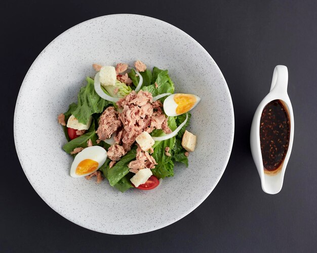Top view of Boiled egg and tuna with green cos lettuce salad isolated on black background