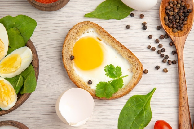Вид сверху вареные яйца с помидорами и приправами на белом фоне фото еда завтрак обед цвет еда салат