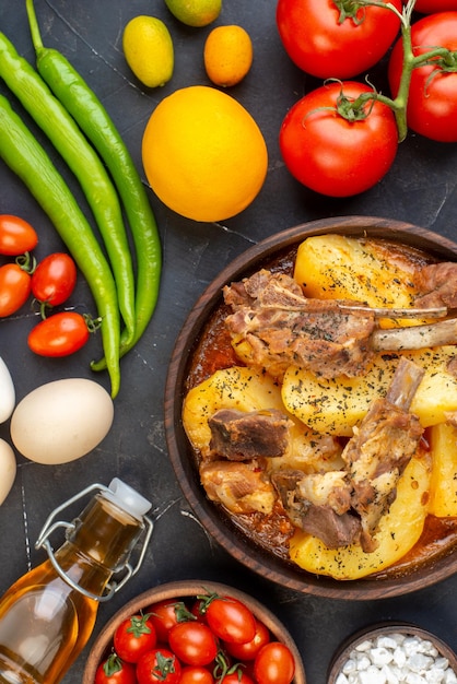 Фото Вид сверху вареное мясо с картофелем и свежими овощами на темном фоне блюдо соус кухня горячая кухня приготовление мяса