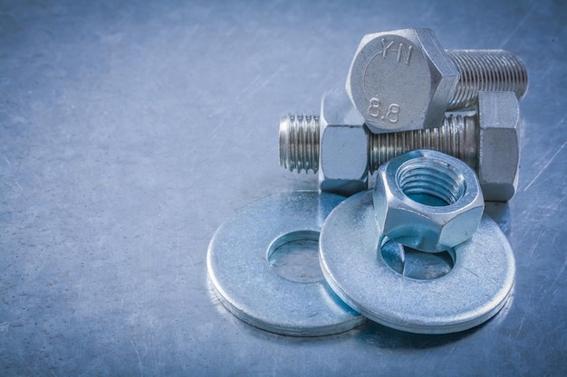 Top view of bolt washers screwbolts screwnuts on metallic background