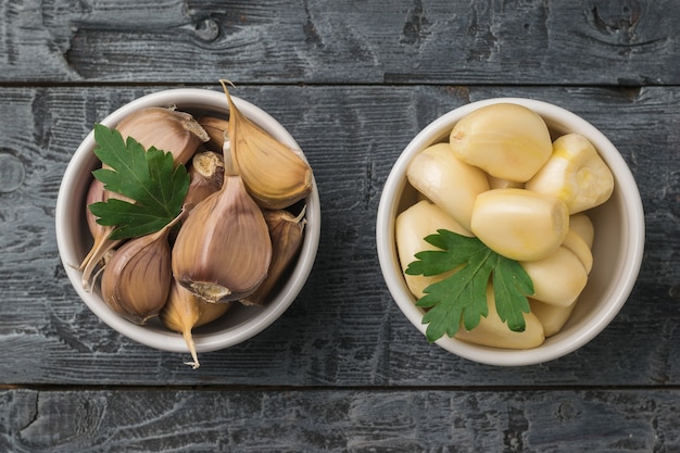 Top view of the bowls of peeled and unpeeled garlic. A popular spice for the kitchen.