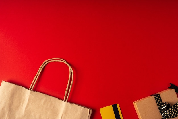 Top view of boxes, paper bag and gift on red background