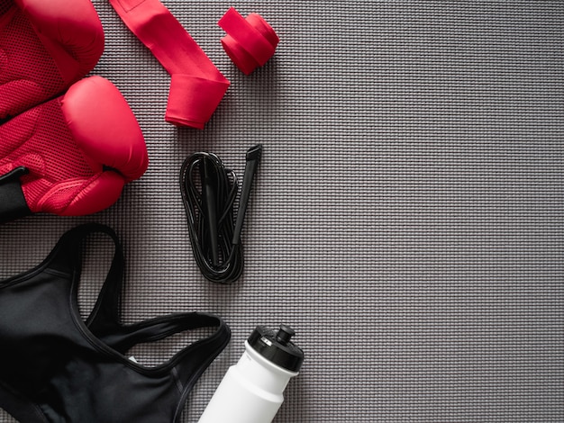 взгляд сверху концепции спортзала бокса с боксерской перчаткой, оборудованием спортзала, прыгая веревочкой и аксессуарами на предпосылке циновки йоги.