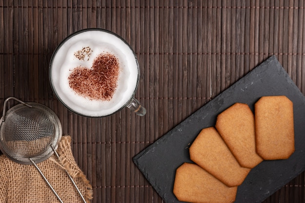 Top view of breakfast with cookies and coffee with a heart