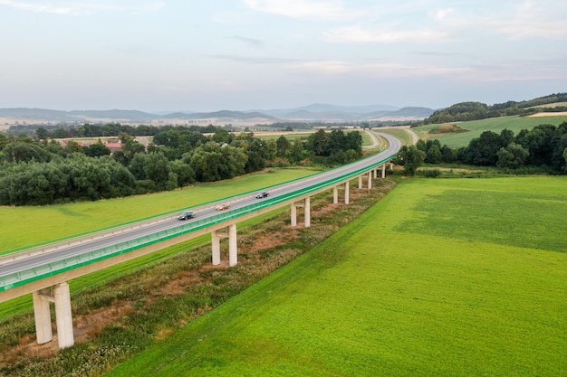 Top view of bridge road over green fields