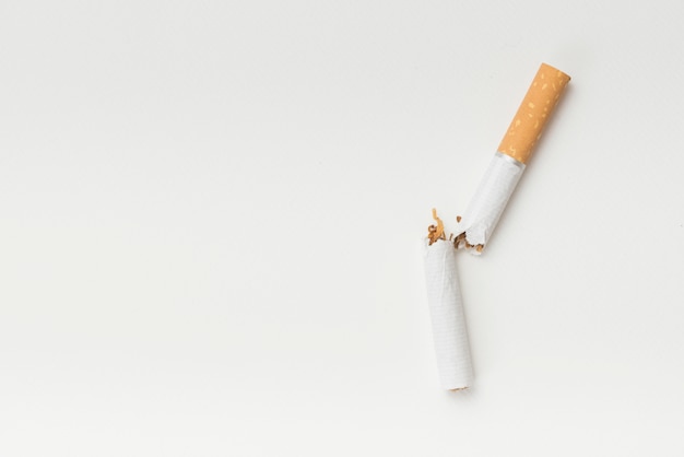 Photo top view of broken cigarette on white background