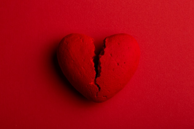 Photo top view broken heart on red background