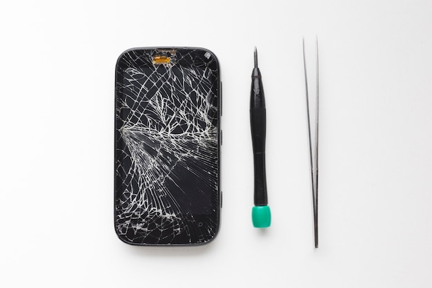 Top view broken smartphone with repair tools