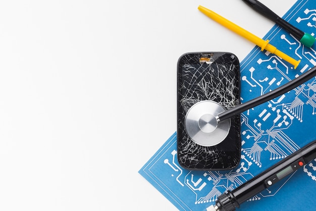 Top view broken smartphone with repair tools