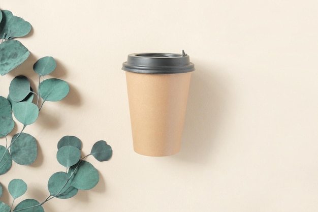 Top view of a brown coffee paper cup mockup black lid to go cup\
for coffee tea on beige take away