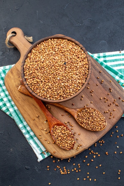 top view brown raw buckwheat inside plate on dark background color food seed health dinner fresh plant lentil