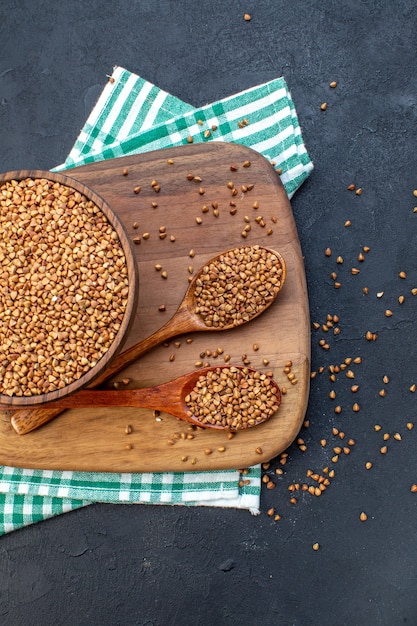 top view brown raw buckwheat inside plate on dark background color food seed health fresh plant lentil meal