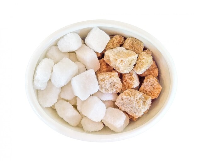 Top view of brown and white sugar cubes in bowl isolated