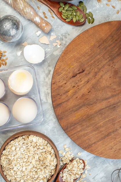 top view brown wooden desk with fruits eggs raw cereals and seeds on the white background dough pie seed fruit color corn cook cake milk