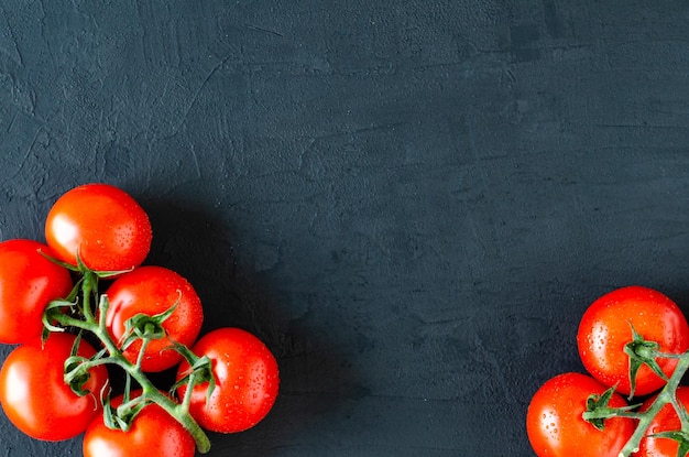 Top view of bunch of fresh tomatoes on black background