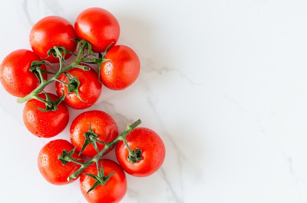 Top view of bunch of fresh tomatoes on white marble background