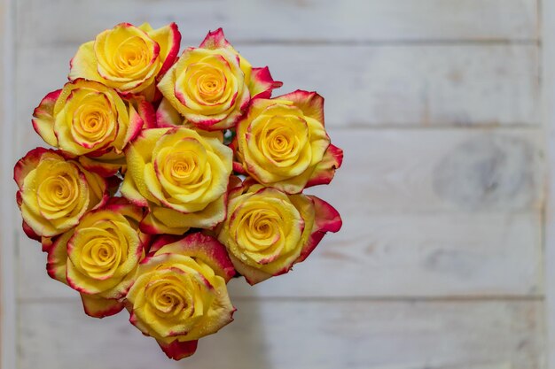 Top view of bunch of roses of yellow and red colors with water drops greeting card concept