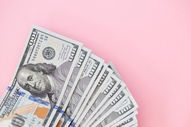 Top view of bundle of 100 dollar bill on pink background Business concept with copy space