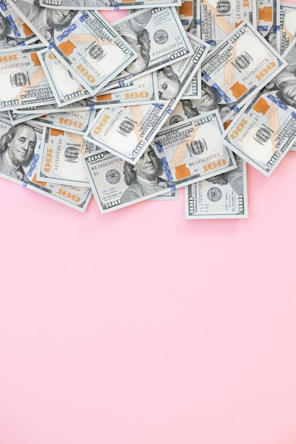 Top view of bundle of 100 dollar bill on pink background Business concept with copy space