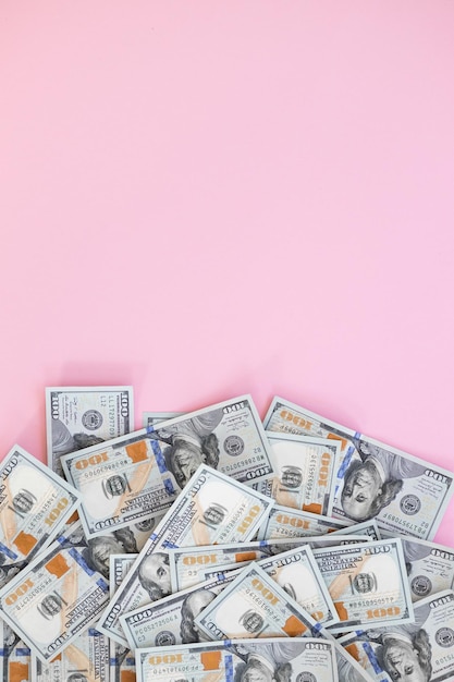 Top view of bundle of 100 dollar bill on pink background Business concept with copy space