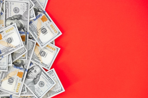 Photo top view of bundle of 100 dollar bill on red background business concept with copy space