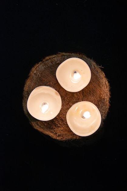 Top view of burning candles on dark wall