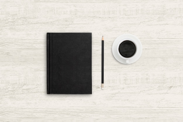 Top view business background of notebook and coffee cup on wood texture.
