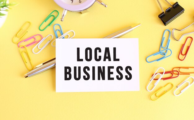 Top view of a business card with text local business on a yellow background