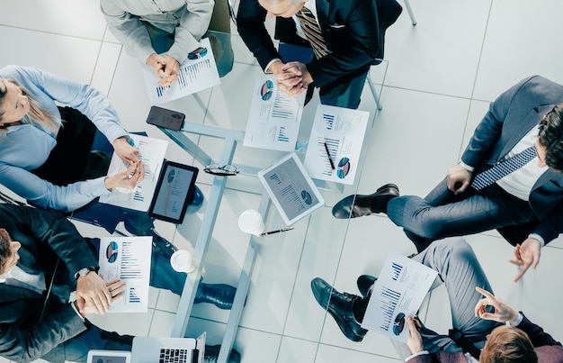 Top view business colleagues sitting at the office desk