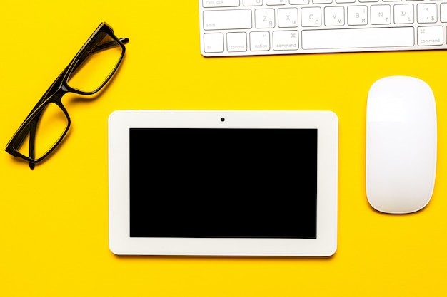 Top view of business working place with cup of coffee, Empty workspace on yellow table .